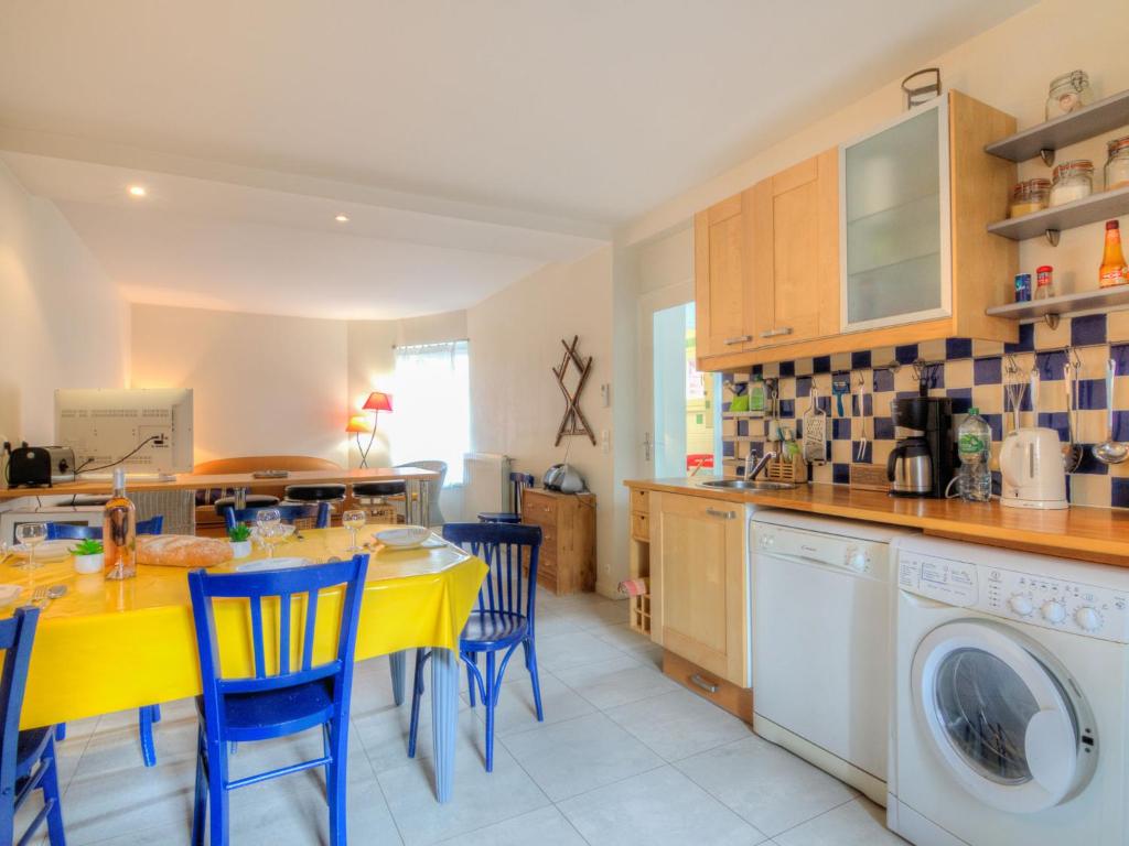 une cuisine avec une table jaune et des chaises bleues dans l'établissement Holiday Home Petit Acacia by Interhome, à Dinard