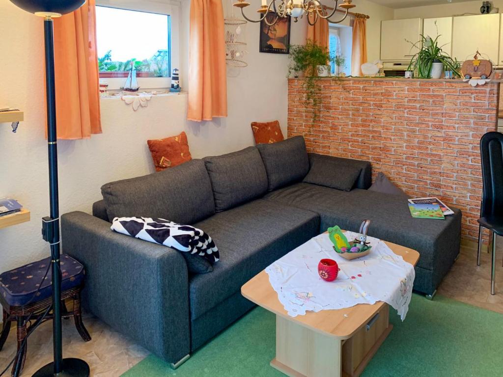 ein Wohnzimmer mit einem Sofa und einem Tisch in der Unterkunft Apartment Buss by Interhome in Utarp