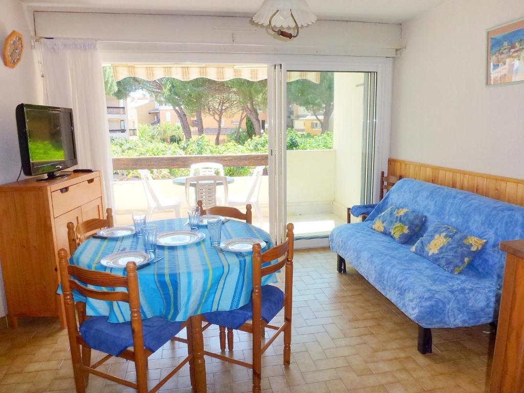 un salon avec une table et un canapé dans l'établissement Apartment Camargue Village-2 by Interhome, au Grau-du-Roi
