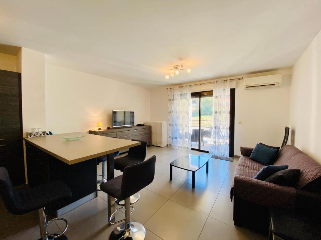 un salon avec une table et un canapé dans l'établissement PORTO PIANO 2 pièces au coeur de la ville, à Propriano