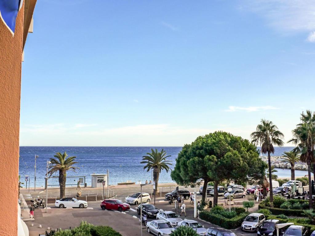 um parque de estacionamento junto ao oceano com palmeiras em Apartment Le Méditerranée-2 by Interhome em Fréjus