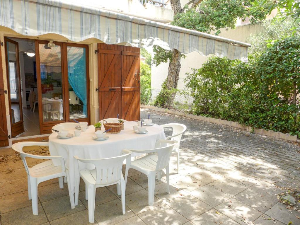 a white table and chairs on a patio at Holiday Home Le Mas des Calanques by Interhome in Saint-Aygulf