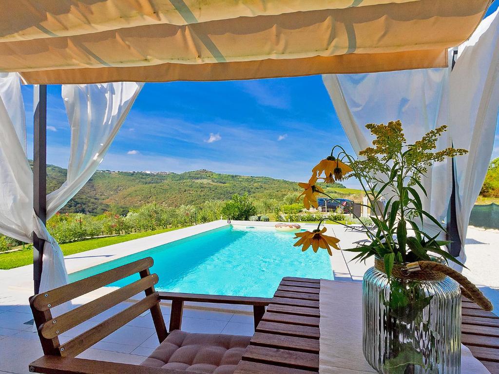 a swimming pool with a table and a vase of flowers at Holiday Home Ravan by Interhome in Brkač