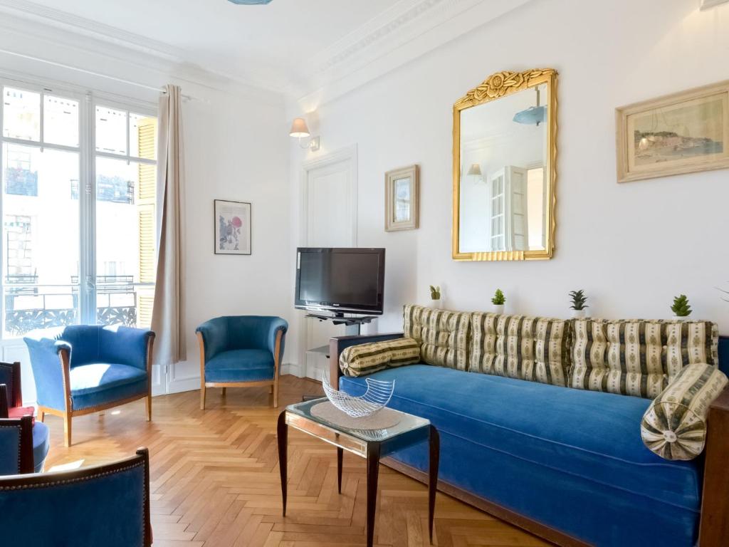 un salon avec un canapé bleu et une télévision dans l'établissement Apartment Le Rossini by Interhome, à Nice