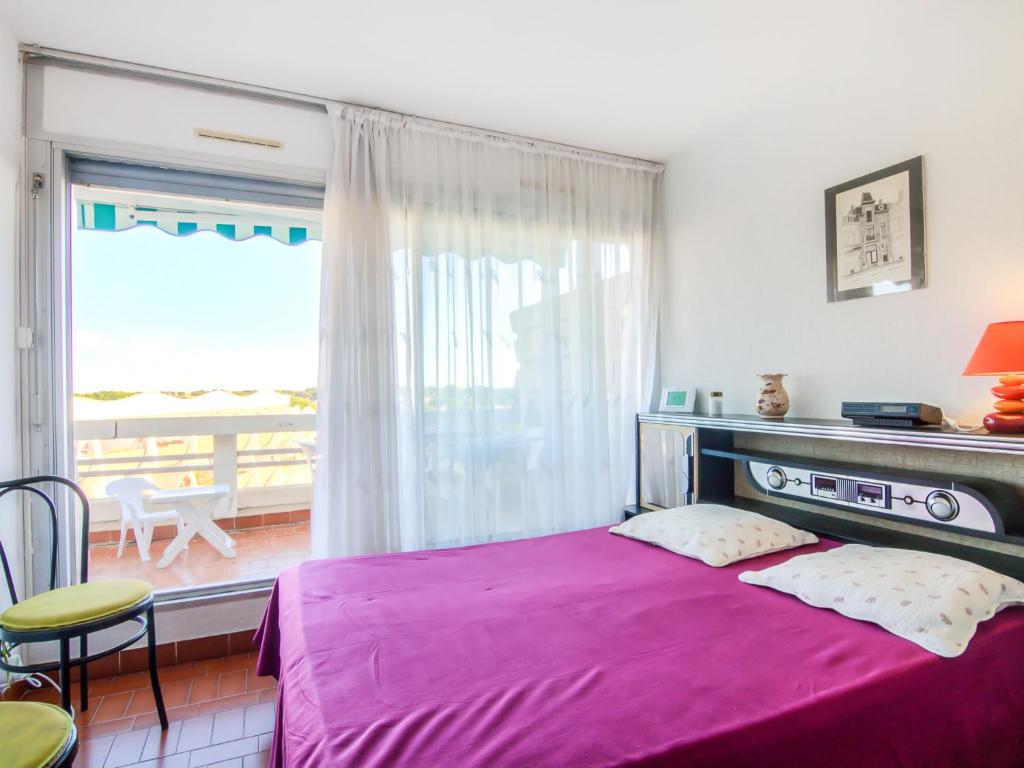 ル・グロー・デュ・ロワにあるApartment Le Quai aux Fleurs-3 by Interhomeの紫色のベッドとバルコニー付きのベッドルーム1室