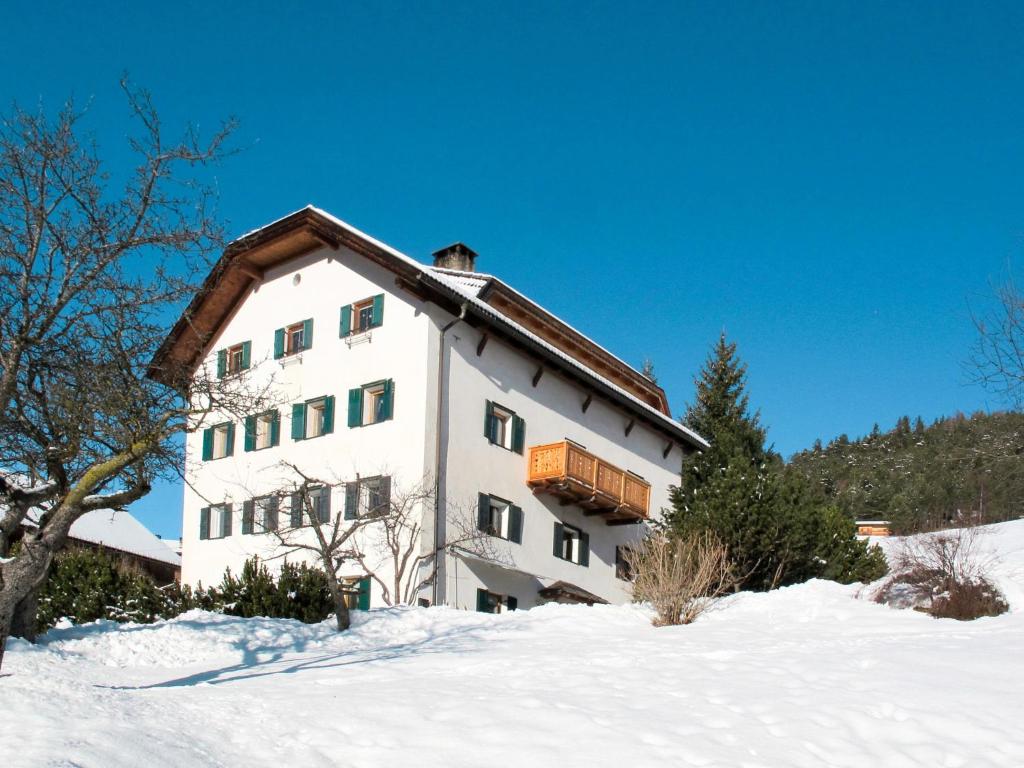 a white building with a balcony in the snow at Apartment Luca by Interhome in Ortisei