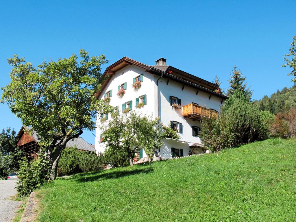 una casa bianca in cima a una verde collina di Apartment Luca by Interhome a Ortisei