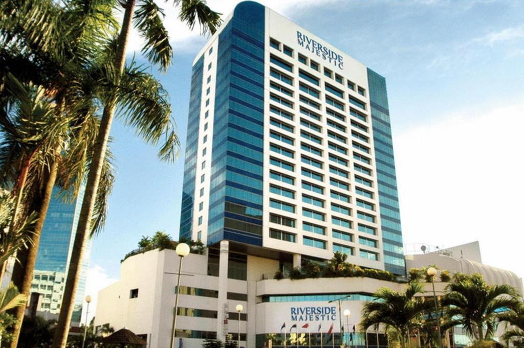 クチンにあるPuteri Wing - Riverside Majestic Hotelのヤシの木が目の前にそびえる高い建物