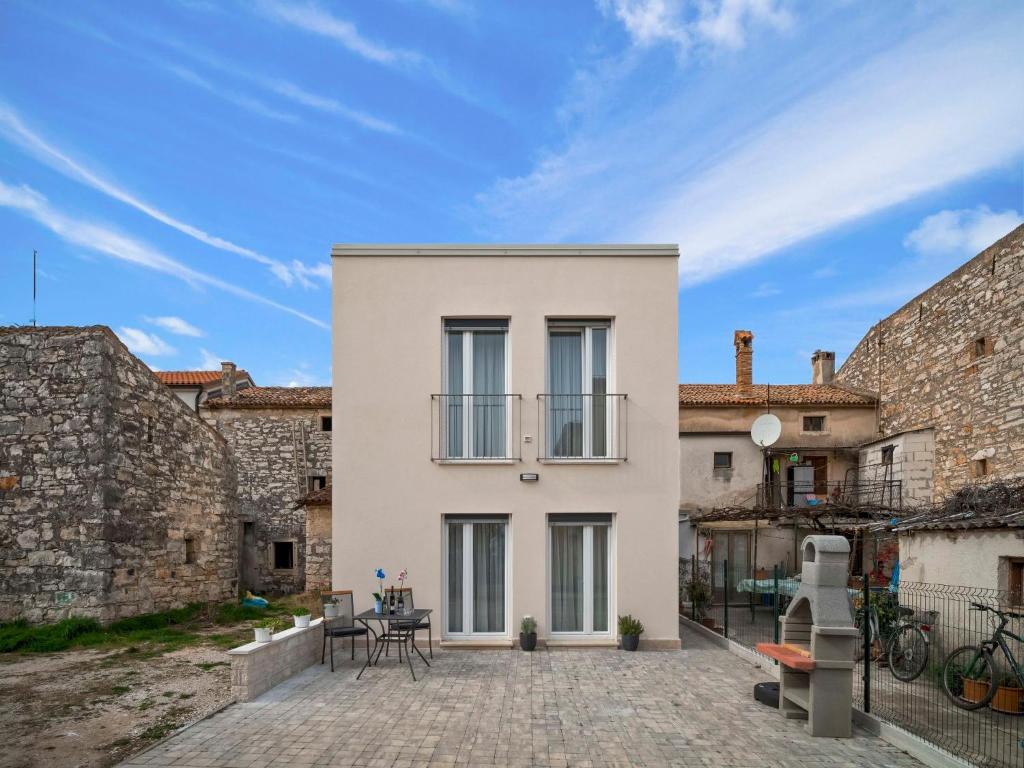 een wit huis met een patio op een binnenplaats bij Holiday Home Dario by Interhome in Novigrad Istria
