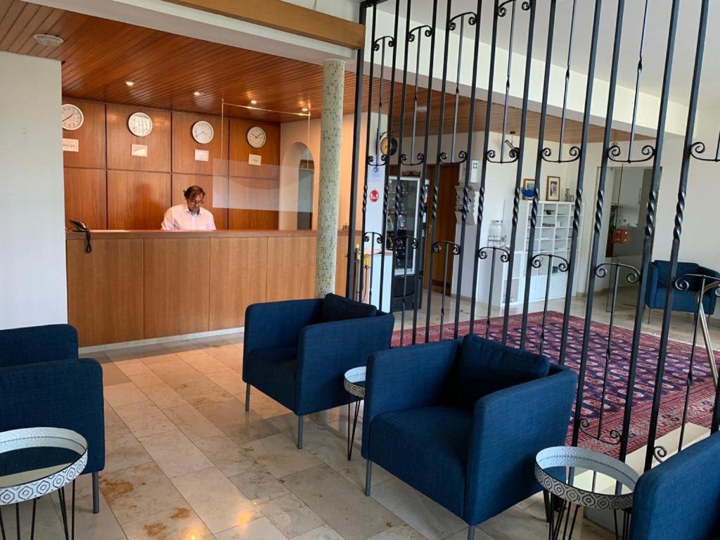 バート・ベリンゲンにあるHotel Markgrafの待合室の窓口の後ろに立つ女