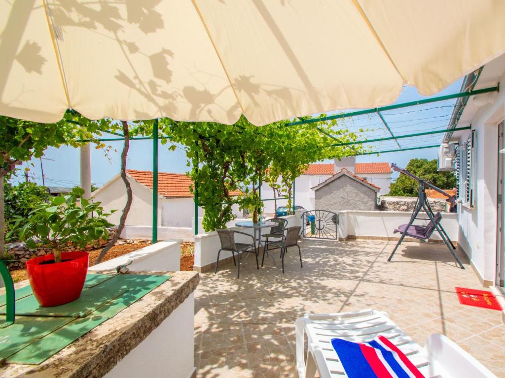 une terrasse avec une table, des chaises et un parasol dans l'établissement Holiday Home Snježana by Interhome, à Ražanj