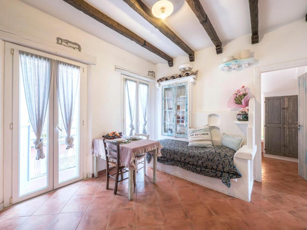 een woonkamer met een tafel, stoelen en ramen bij Apartment Palazzo Antiche Porte-2 by Interhome in Rimini