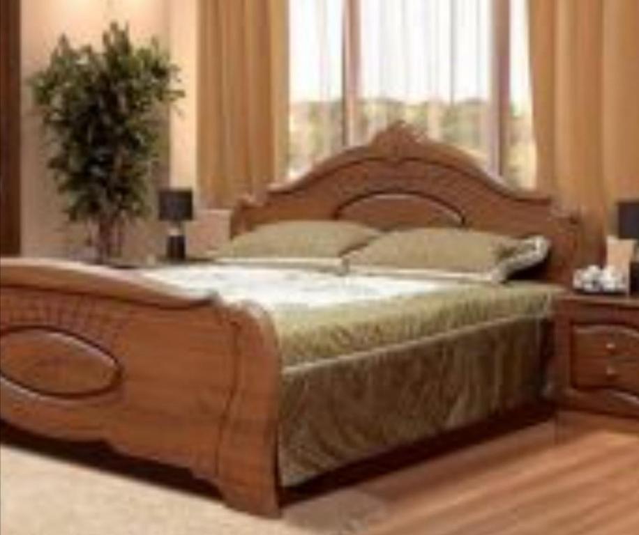 1 dormitorio con cama de madera y ventana en Сomfort&Servis Apartment on Mira of Yuzhny en Yuzhne