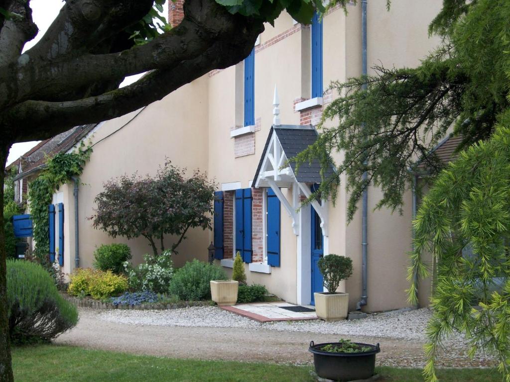 a house with blue shutters and a driveway at Loire, Châteaux, et Vignes in Onzain