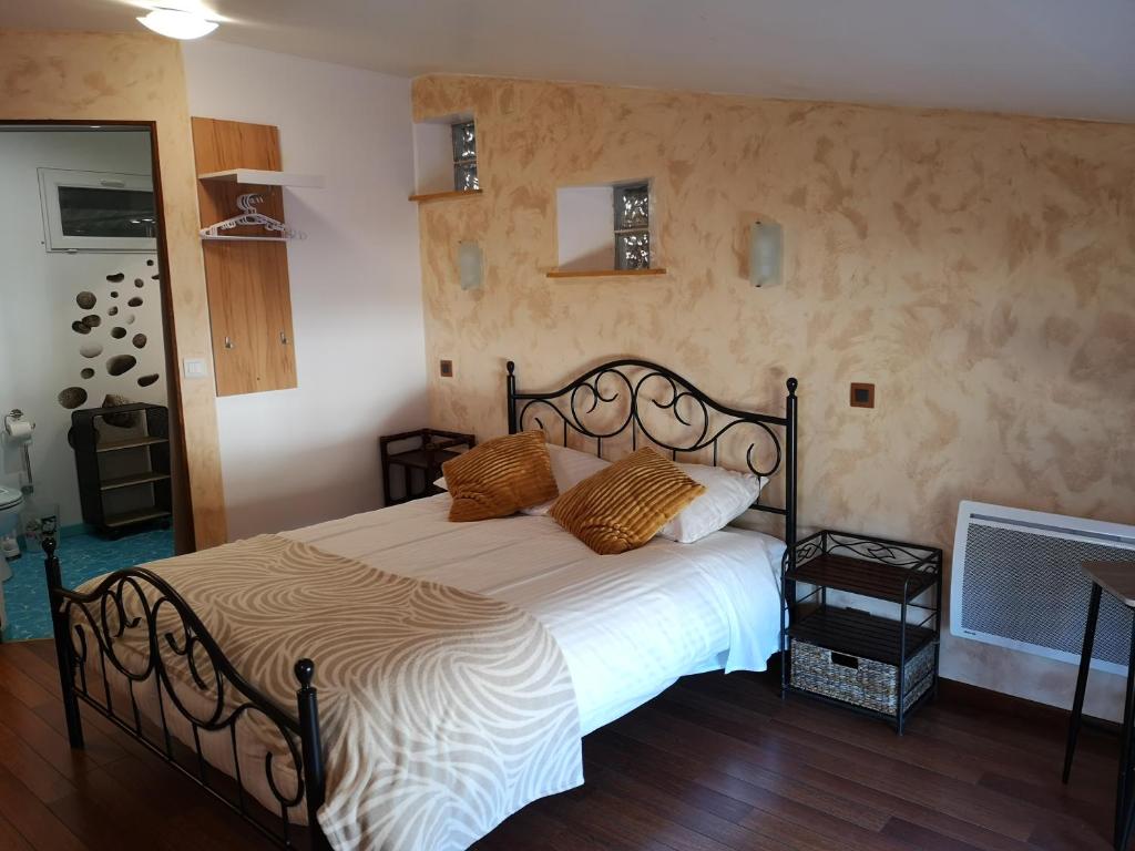 a bedroom with a bed with white sheets and orange pillows at Launie Lea in Eyzerac