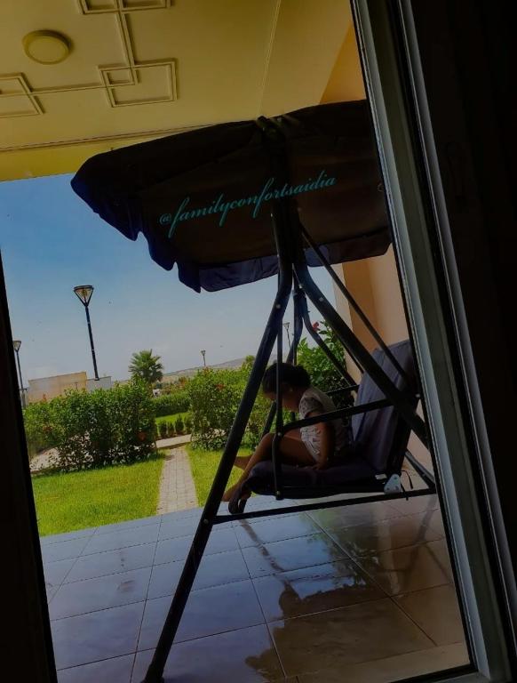 a person sitting in a chair under an umbrella at FamilyConfort Saidia in Saïdia