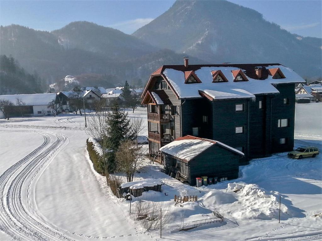 een groot gebouw in de sneeuw met bergen op de achtergrond bij Apartment Spatzennest - Top 7 by Interhome in Grünau im Almtal
