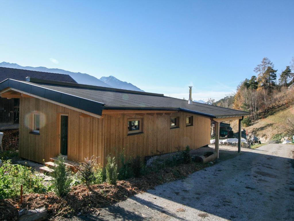 una pequeña casa de madera en un camino de tierra en Chalet Shakti by Interhome en Reith bei Seefeld