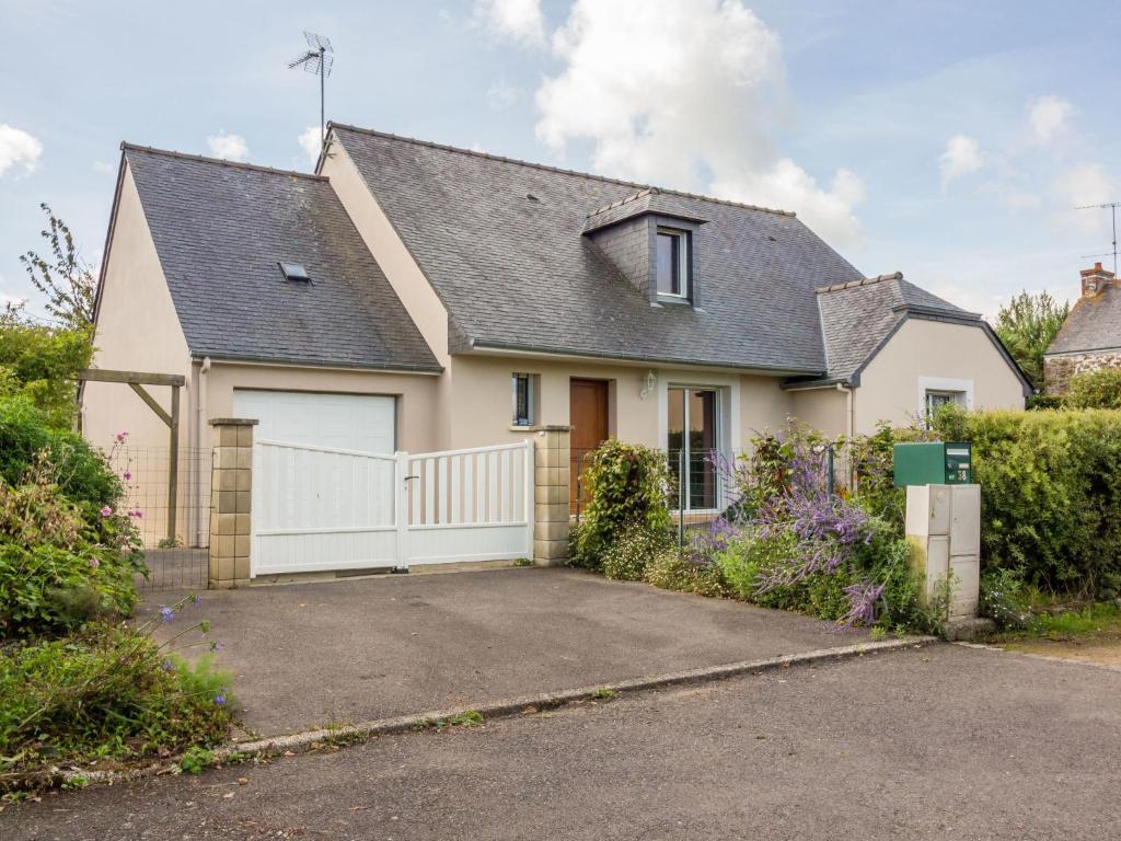 ein Haus mit einem weißen Zaun und einer Auffahrt in der Unterkunft Holiday Home Maison Les Hortensias by Interhome in Pleurtuit