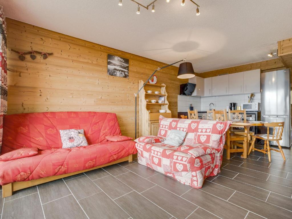 a living room with a red couch and a table at Apartment Champ Bozon by Interhome in La Toussuire