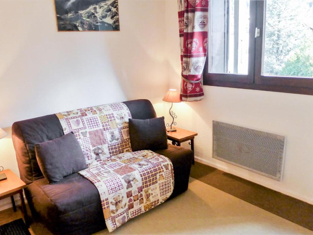un salon avec un canapé et une fenêtre dans l'établissement Apartment Champraz-15 by Interhome, à Chamonix-Mont-Blanc