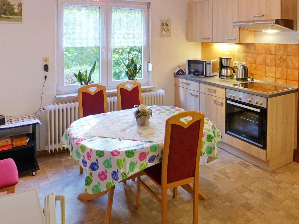 uma cozinha com uma mesa e cadeiras e uma cozinha com uma mesa e uma mesa em Apartment Landhaus Bischoff by Interhome em Südbrookmerland