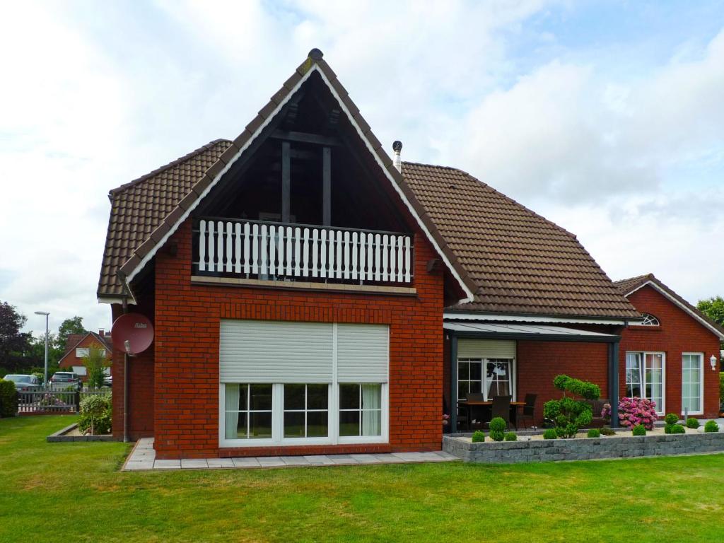 a red brick house with a gambrel roof at Apartment Alina by Interhome in Marienhafe