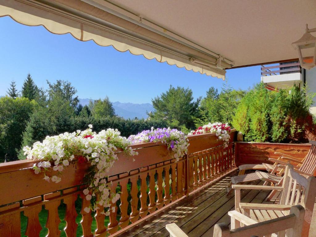 a balcony with flowers on a wooden fence at Apartment Soldanella by Interhome in Crans-Montana