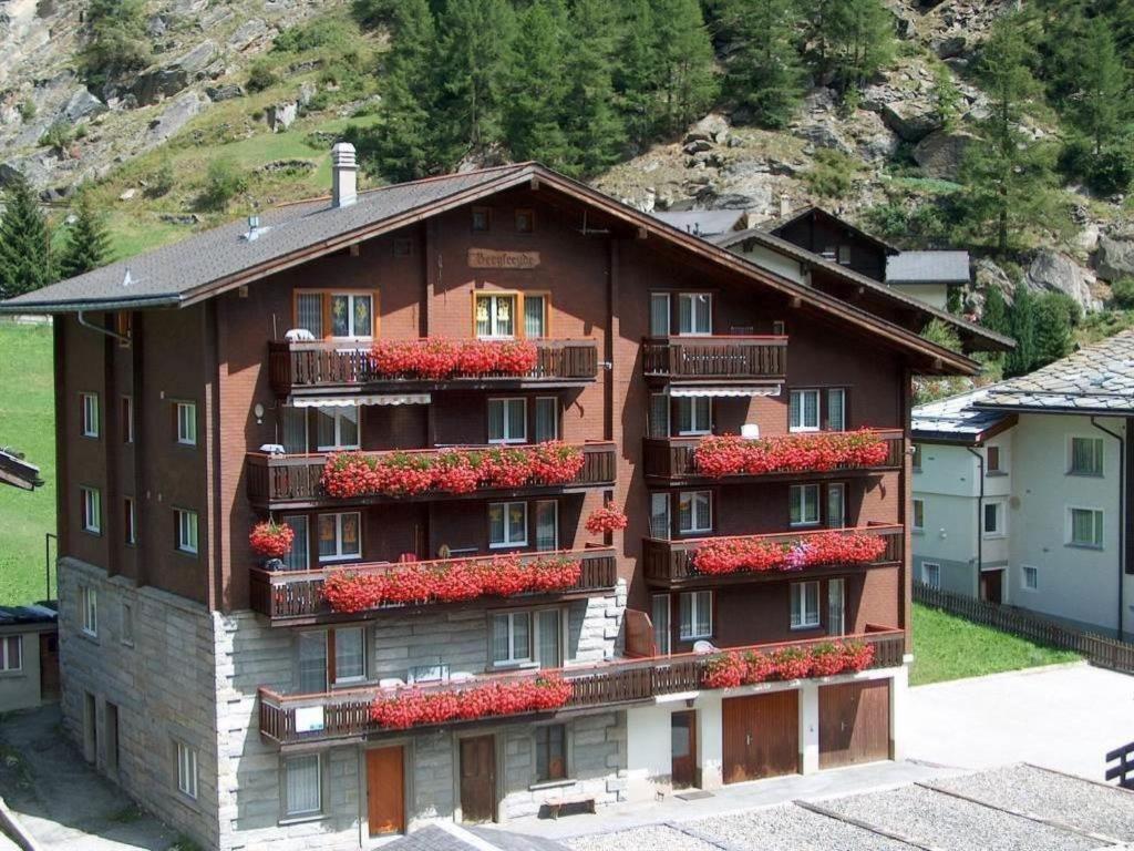 a building with red flowers on the side of it at Apartment Bergfreude Kuonen by Interhome in Saas-Grund