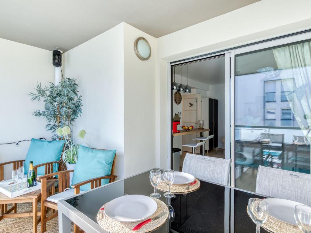 a dining room with a glass table and chairs at Apartment Le Newport-2 by Interhome in Fréjus