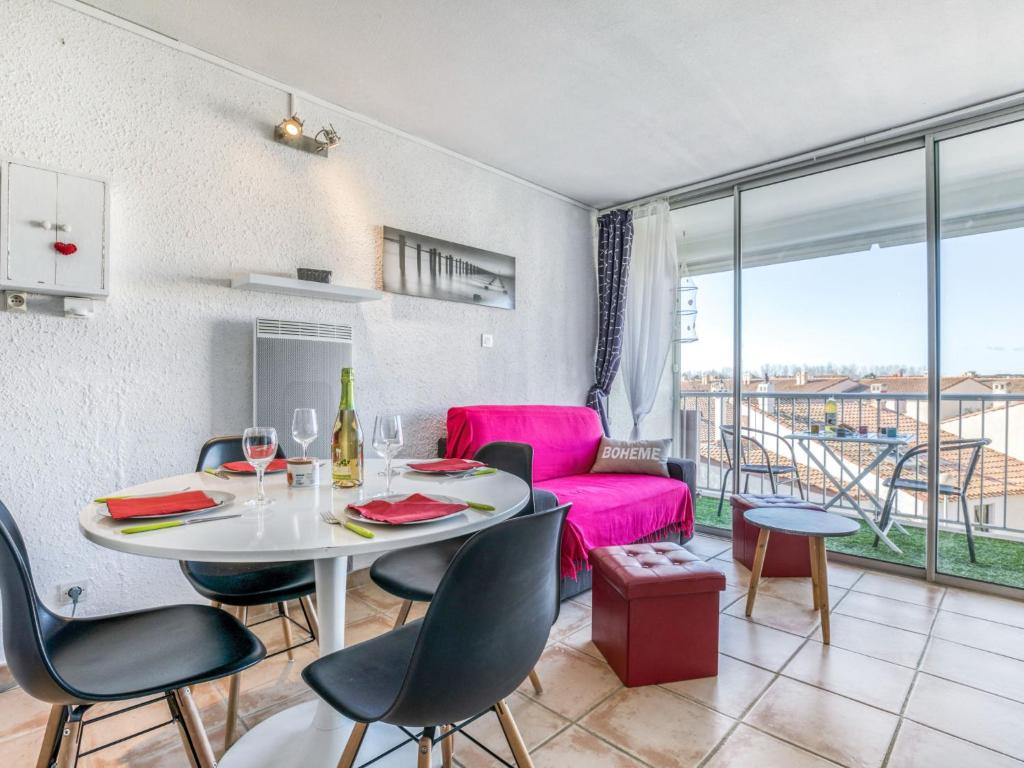 - un salon avec une table et un canapé rose dans l'établissement Apartment Les Saladelles-10 by Interhome, au Grau-du-Roi