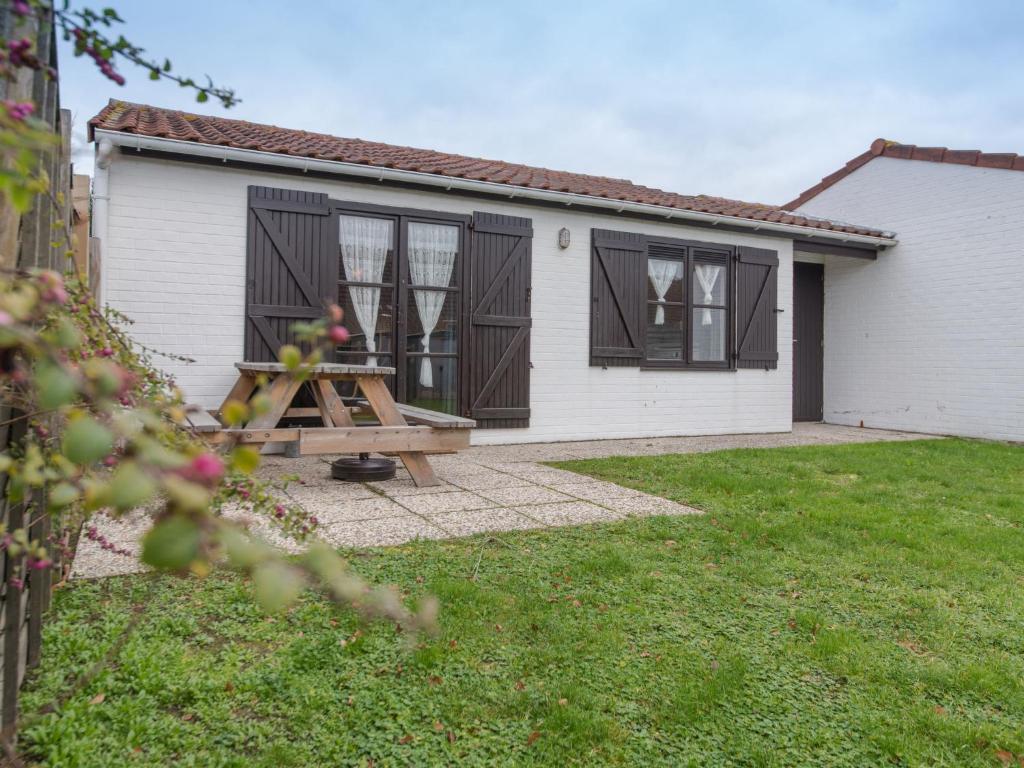 デ・ハーンにあるHoliday Home Polderhuis nr-142 by Interhomeの庭のピクニックテーブル付き家