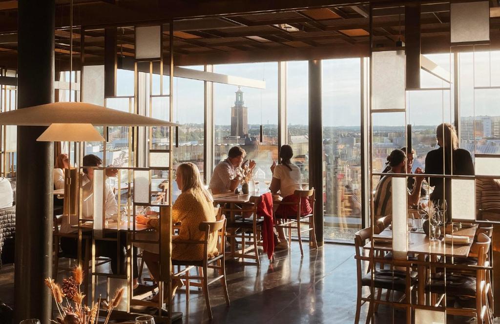 un gruppo di persone seduti ai tavoli in un ristorante di Hobo Hotel Stockholm a Stoccolma