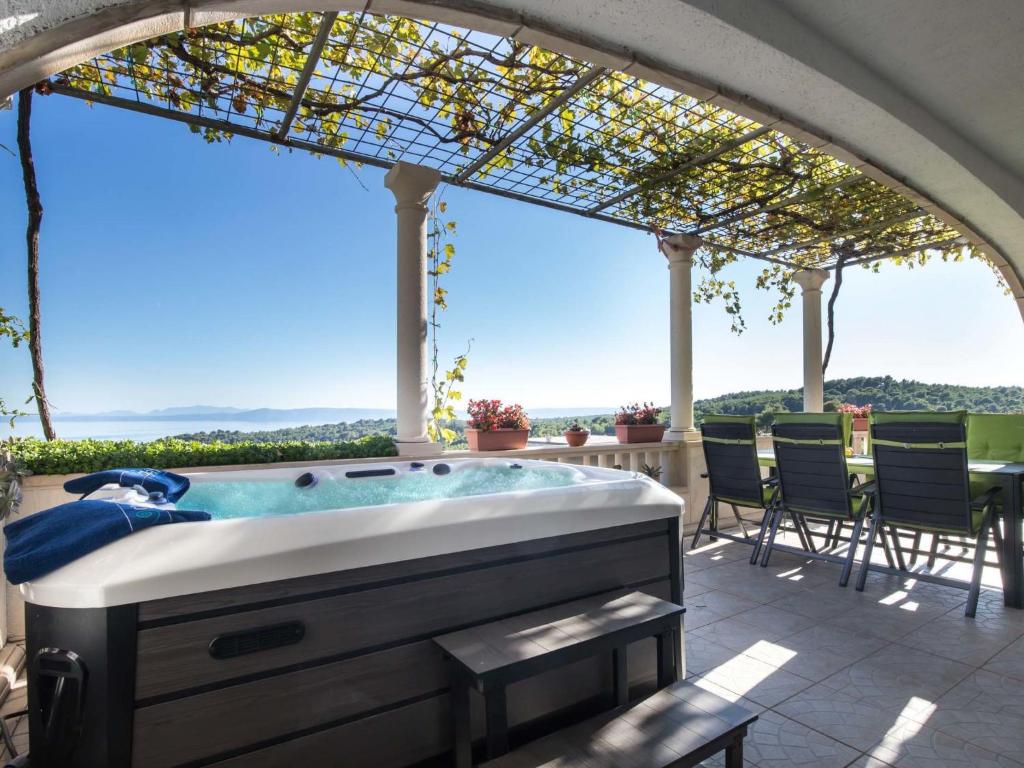 a hot tub on a patio with a view at Holiday Home Ivana by Interhome in Selca