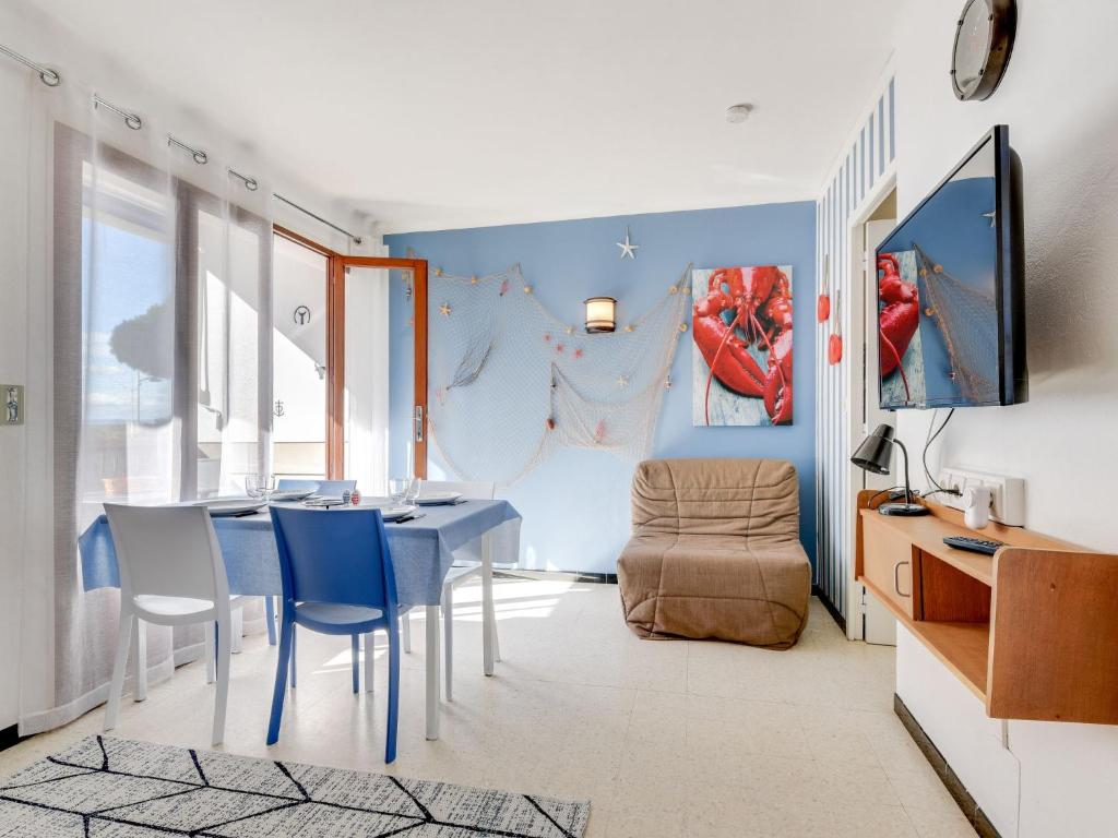 een eetkamer met een blauwe tafel en stoelen bij Studio Le Mercure by Interhome in Le Grau-du-Roi