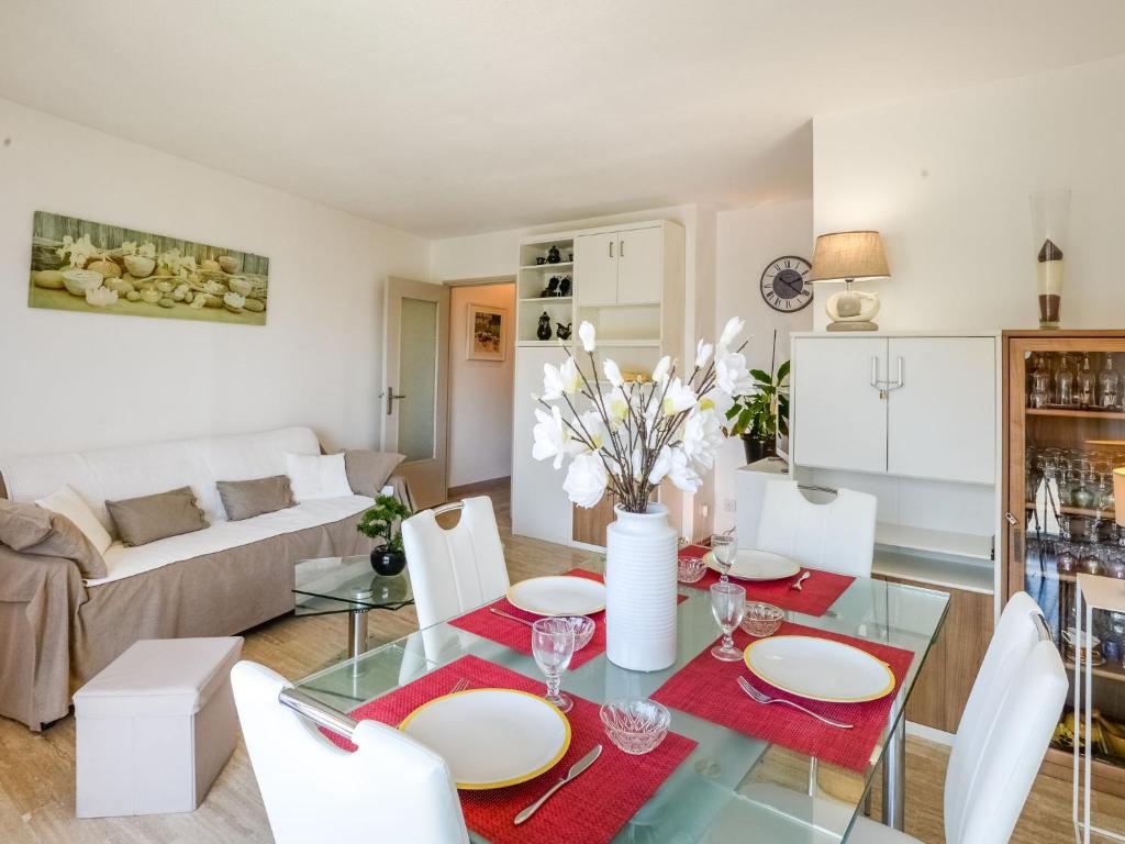 - un salon avec une table en verre et des chaises blanches dans l'établissement Apartment Le Poséidon by Interhome, à Cagnes-sur-Mer