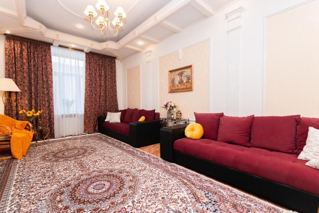ein Wohnzimmer mit einem roten Sofa und einem Tisch in der Unterkunft Lakshmi Apartment Great Classic in Moskau