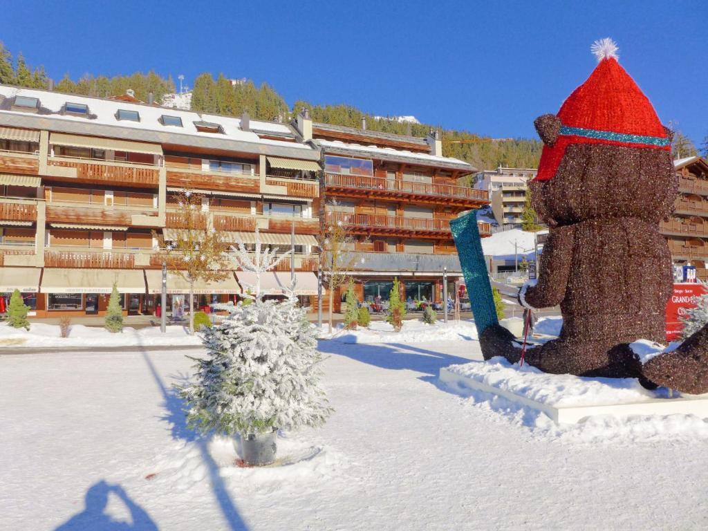 a teddy bear statue in the snow in front of a building at Apartment les Vignettes by Interhome in Crans-Montana