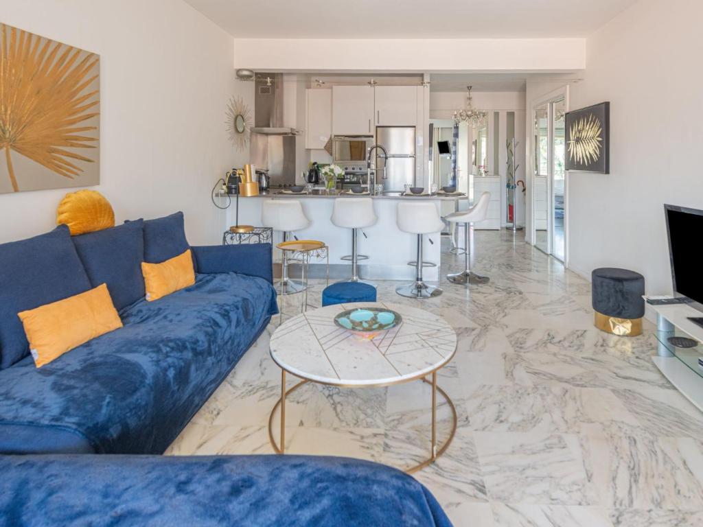 - un salon avec un canapé bleu et une table dans l'établissement Apartment Presqu'Ile by Interhome, à Cannes