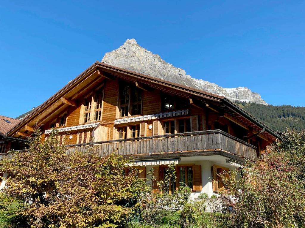 a large wooden house with a mountain at Apartment Haus Lohnerblick by Interhome in Kandersteg
