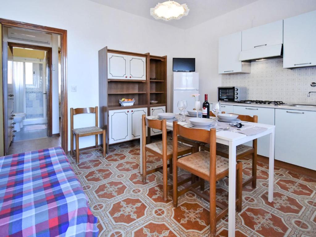 uma cozinha com mesa e cadeiras num quarto em Apartment Casa Armida-4 by Interhome em Rosolina Mare