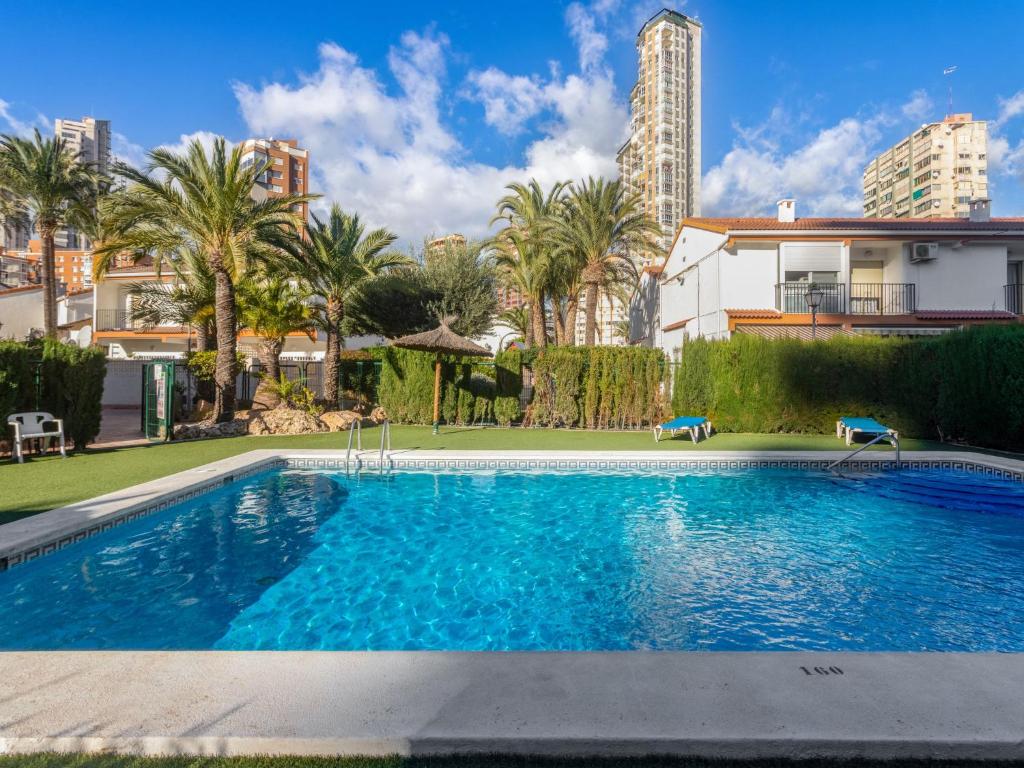 ein Pool mit Palmen und ein Gebäude in der Unterkunft Apartment Rinconada Real by Interhome in Benidorm