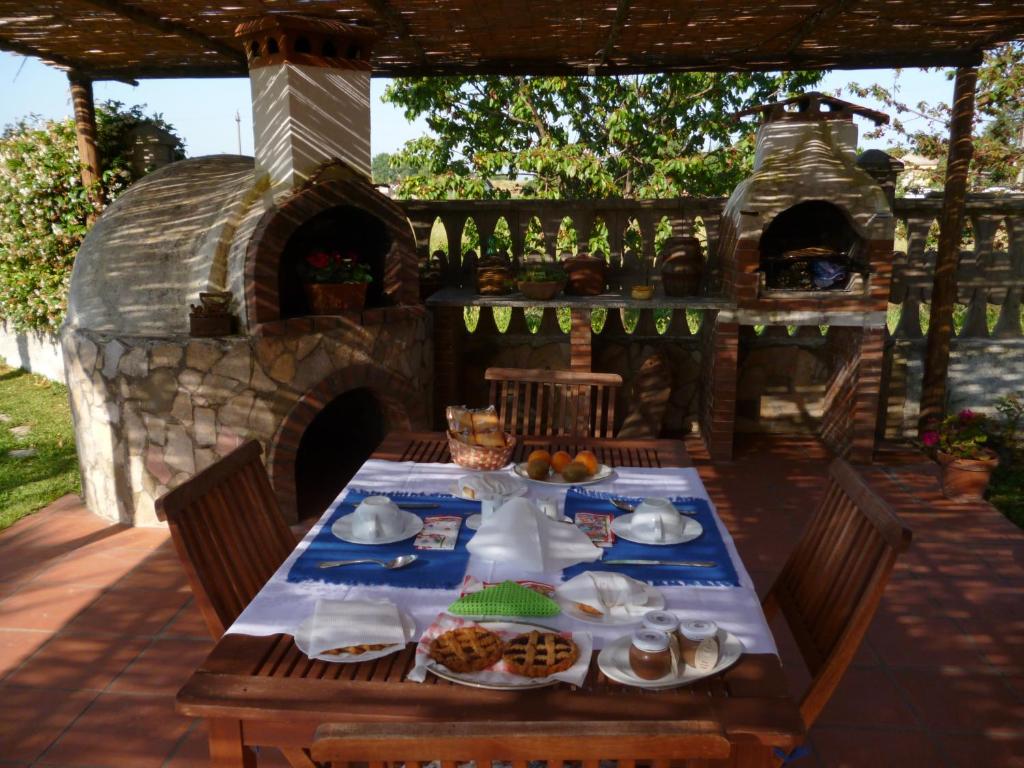 una mesa con comida y un horno al aire libre en B&B La Taverna dei Ciucci en Foce del Sele