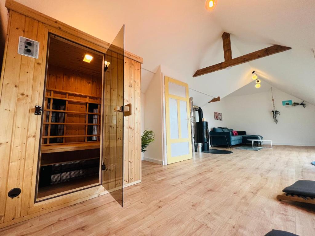 a living room with a wooden floor and a door at Auszeit-Eifel „Eifelhorst“ in Willwerscheid