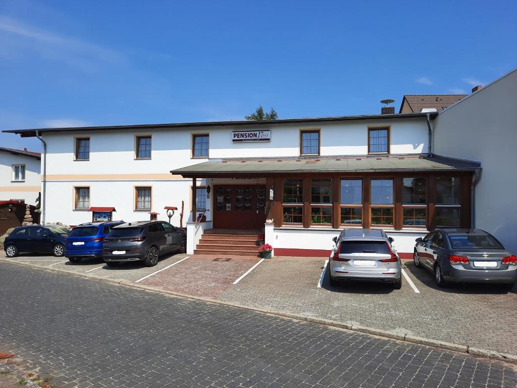 a building with cars parked in front of it at Pension Voss in Ueckeritz