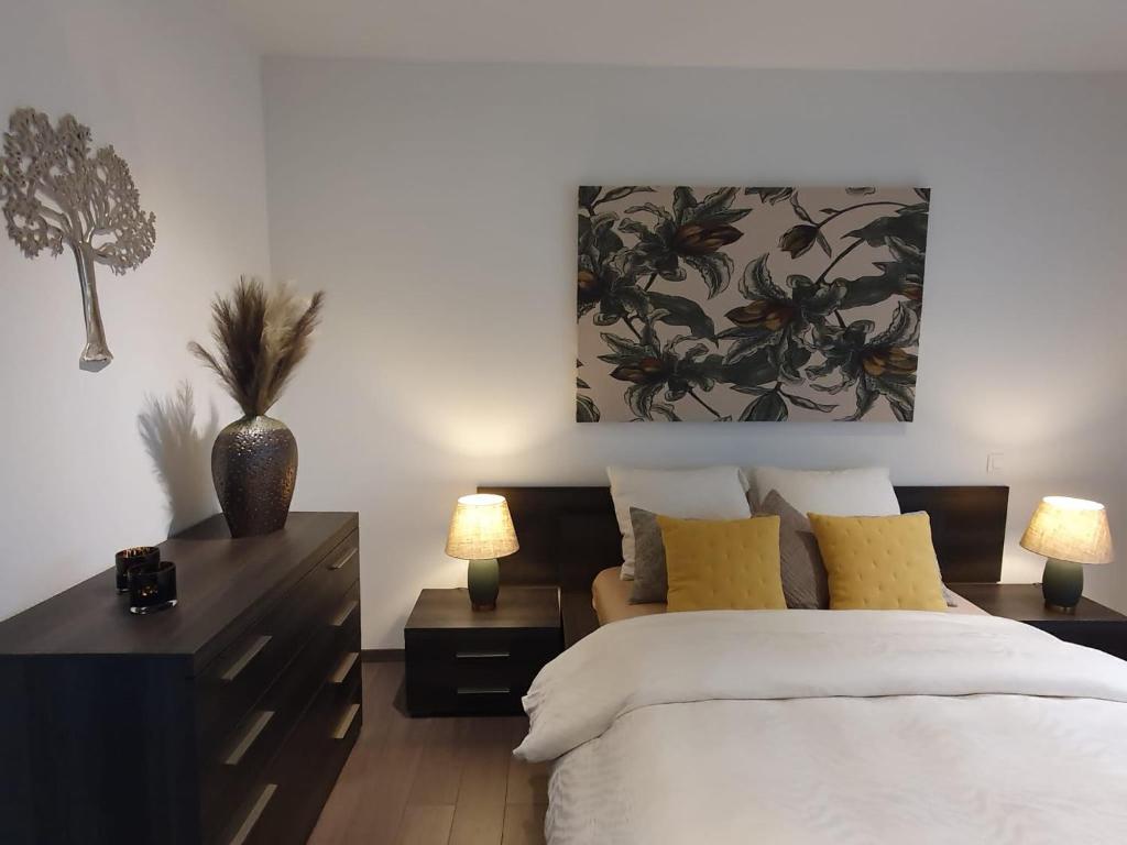een slaapkamer met een bed en een schilderij aan de muur bij The first Harmony in Spa