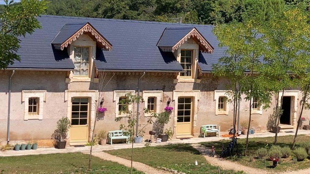 una casa con techo azul y puertas amarillas en La Cour de La Fleunie 1, en La Machome