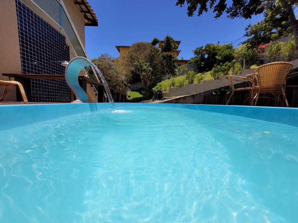 uma grande piscina azul com uma fonte de água em Condomínio Solar João Fernandes em Búzios