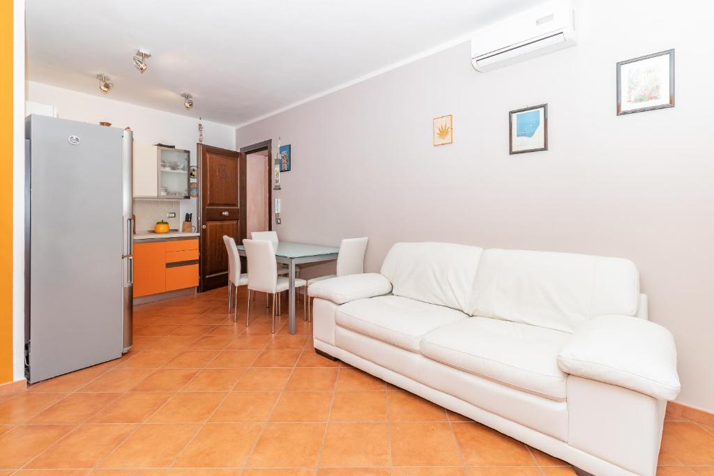 sala de estar con sofá blanco y mesa en Sinner House, en Valledoria