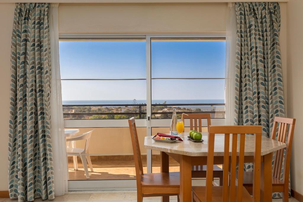 a dining room with a table and a large window at Interpass Vau Hotel Apartamentos in Portimão